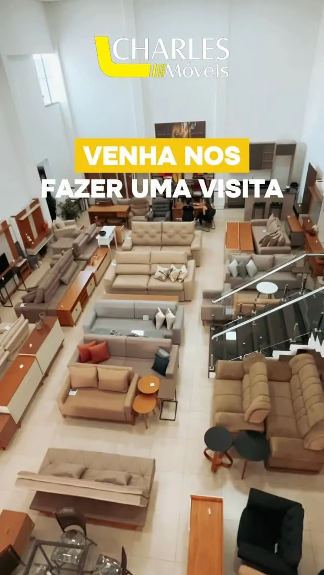 Vista do mezanino do showroom da Charles Móveis com sofás e painéis